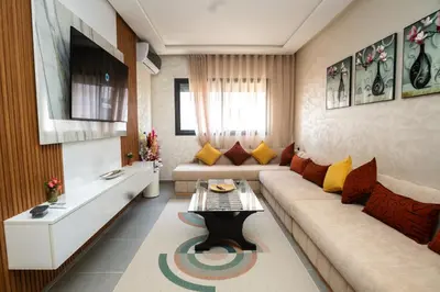 a living room with a couch and a table at Oasis Urban & Balcon - 5 min de l'aeroport in Marrakech