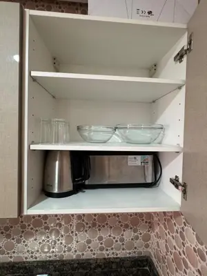 a kitchen cupboard with two glasses and a microwave at Location Centrale - Heated 1BR - Parking - Netflix in Marrakech