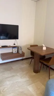 a living room with a table and a tv at Location Centrale - Heated 1BR - Parking - Netflix in Marrakech