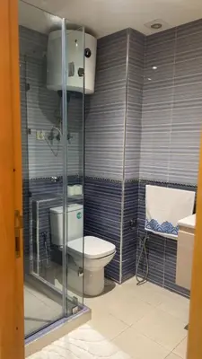 a bathroom with a toilet and a glass shower at Location Centrale - Heated 1BR - Parking - Netflix in Marrakech