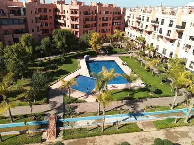 an aerial view of a park with a swimming pool and buildings at Your chic retreat under the Marrakesh sun in Marrakech