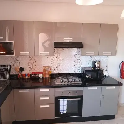 a kitchen with gray cabinets and a stove top oven at Your chic retreat under the Marrakesh sun in Marrakech
