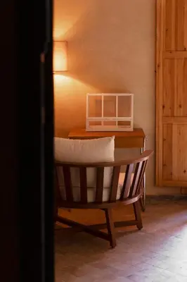 a wooden chair with a desk with a pillow at Riad Johara Marrakech in Marrakech