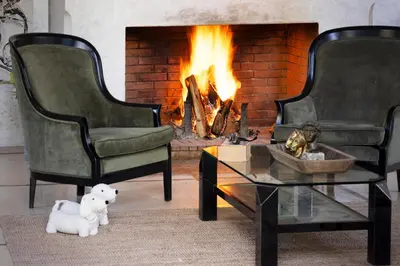 a living room with two chairs and a fireplace at Riad Johara Marrakech in Marrakech