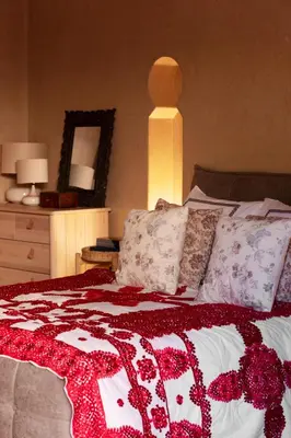 a bed with a red and white blanket and pillows at Riad Johara Marrakech in Marrakech
