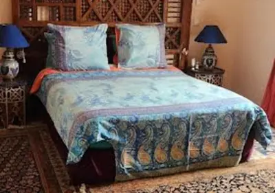 a bedroom with a large bed with a colorful blanket at Private villa Marrakech in Marrakech