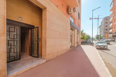 a building with an open door on the side of a street at 2 King Suites 2 Living Rooms 3 min Gueliz Carre Eden in Marrakech