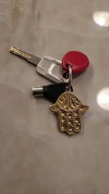 a gold key chain with a knife and a turtle charm at Hébergement Moderne avec Esprit Riad a l'Hivernage in Marrakech