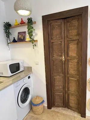 a kitchen with a washing machine and a microwave at Hébergement Moderne avec Esprit Riad a l'Hivernage in Marrakech