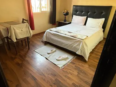 a bedroom with a bed and two slippers on the floor at Appartement Nomade in Marrakech