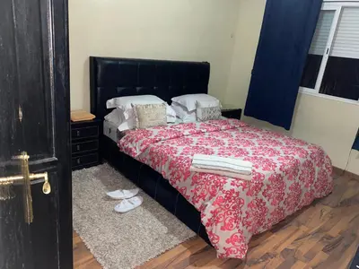 a bedroom with a large bed with a red blanket at Appartement Nomade in Marrakech