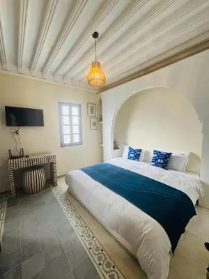 a bedroom with a large bed in a room at Riad l'Oasis Bleue en privatisation 10 pers 3 jours mini in Marrakech