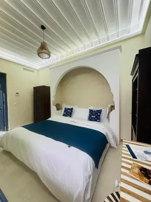 a bedroom with a large bed in a room at Riad l'Oasis Bleue en privatisation 10 pers 3 jours mini in Marrakech
