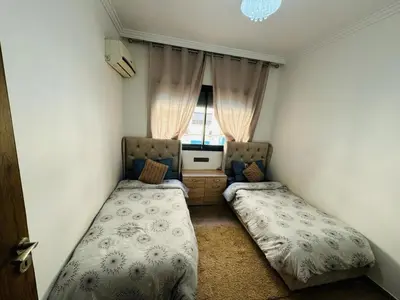 a bedroom with two beds and a window at Elegant City Apartment in Marrakech