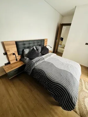 a bedroom with a large bed with a wooden floor at Elegant City Apartment in Marrakech