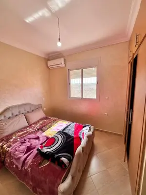 a bedroom with a bed and a window at Apartmen rentals with M Z in Oulad Akkou