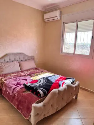 a large bed in a room with a window at Apartmen rentals with M Z in Oulad Akkou