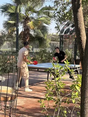 two men playing a game of frisbee at a picnic table at Fekhara CC in Marrakech