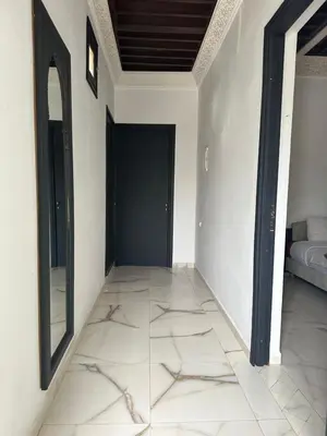 a hallway with a door and a tiled floor at Fekhara CC in Marrakech