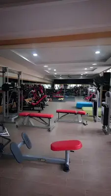 a gym with red and blue tables and benches at Fekhara CC in Marrakech