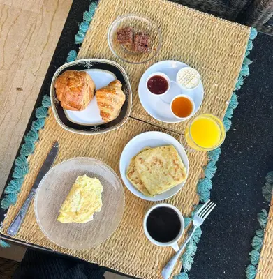 a table topped with plates of breakfast foods and drinks at Fekhara CC in Marrakech