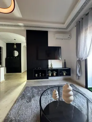 a living room with a glass table and a tv at Modern apartment with Atlas view in Marrakech