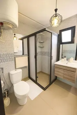 a bathroom with a toilet and a shower and a sink at Modern apartment with Atlas view in Marrakech
