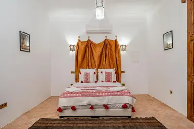 a bedroom with a bed with an orange curtain at Riad Lalla Rachida in Medina Heart Of Marrakech B&B in Marrakech