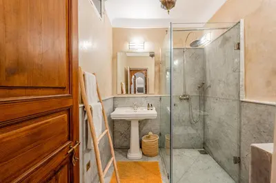 a bathroom with a glass shower and a sink at Riad Lalla Rachida in Medina Heart Of Marrakech B&B in Marrakech