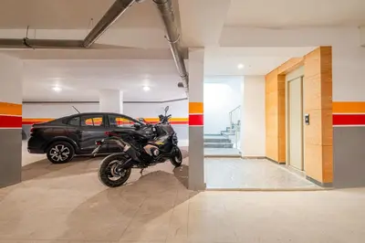 a motorcycle parked in a garage with a car at Stylish Downtown Apartment Optical Fiber Included in Marrakech