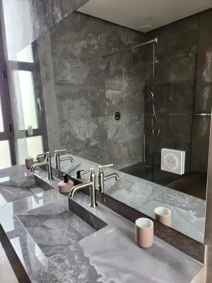 a bathroom with two sinks and a shower at Atlas villa c3 in Sraghna