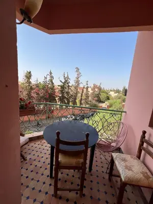 a table and chairs on a balcony with a view at Marakech Giliz Atlas in Marrakech