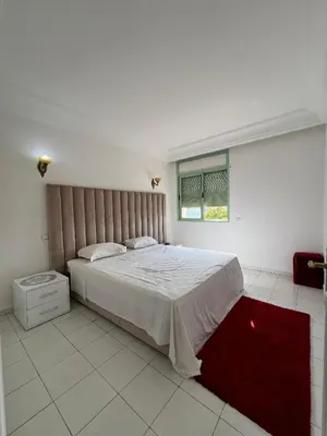a bedroom with a large bed and a red rug at Marakech Giliz Atlas in Marrakech