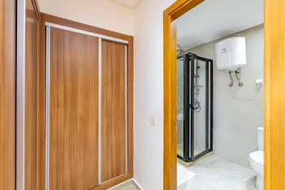 a bathroom with a wooden door and a toilet at Modern Gueliz, Hivernage City Centre 2 Bedroom Apartment in Marrakech
