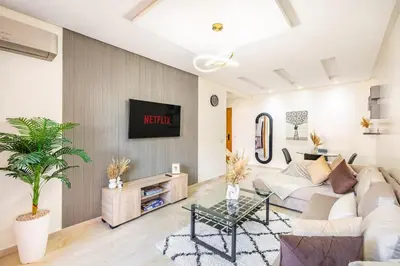 a living room with a white couch and a tv at Modern Gueliz, Hivernage City Centre 2 Bedroom Apartment in Marrakech