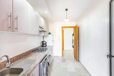 a white kitchen with a sink and a stove at Modern Gueliz, Hivernage City Centre 2 Bedroom Apartment in Marrakech