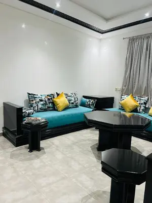 a living room with a blue couch and two tables at Sweet home in Marrakech
