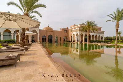 a resort with a swimming pool and palm trees at KAZA BELLA - Palais Les Orchidées in Marrakech