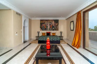 a bedroom with a bed and a painting on the wall at KAZA BELLA - Palais Les Orchidées in Marrakech