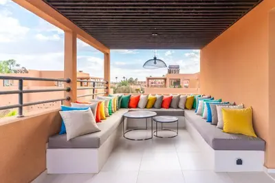 a balcony with colorful pillows and benches on a building at Elegant Villa Free Breakfast Heated Pool Spa in Marrakech