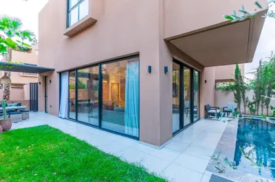 a house with glass doors and a swimming pool at Elegant Villa Free Breakfast Heated Pool Spa in Marrakech