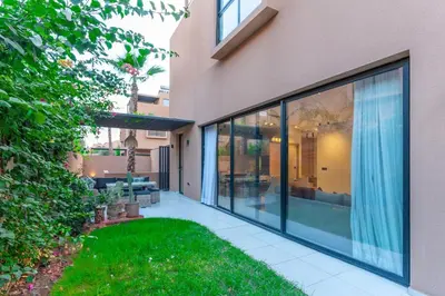 a house with large glass windows and a yard at Elegant Villa Free Breakfast Heated Pool Spa in Marrakech