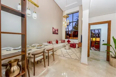 a dining room and living room with a table and chairs at Grand duplex 4 ch - Piscine - Marrakech in Marrakech