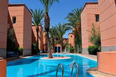 a swimming pool with palm trees in a resort at Riad Pearl Marrakech 4 Rooms Jacuzzi Terrace shared Pool in Marrakech