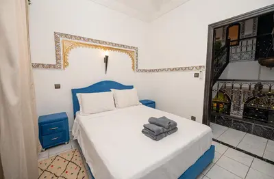 a bedroom with a bed with a blue headboard at Riad Pearl Marrakech 4 Rooms Jacuzzi Terrace shared Pool in Marrakech
