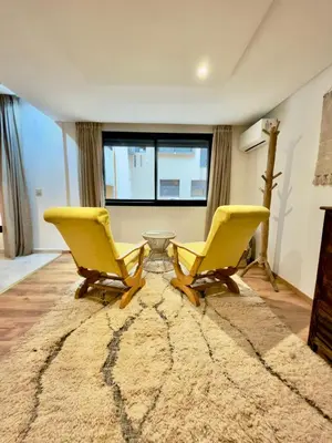 two yellow chairs and a table in a living room at Charmant Duplex 2BR - quartier Hivernage - Piscine in Marrakech