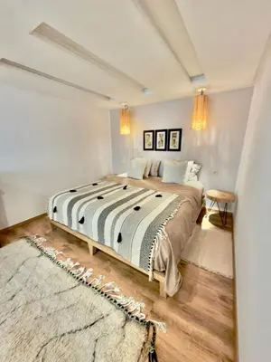 a bedroom with a large bed and a rug at Charmant Duplex 2BR - quartier Hivernage - Piscine in Marrakech