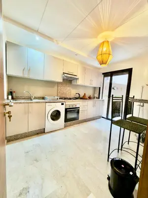 a kitchen with white cabinets and a dishwasher at Charmant Duplex 2BR - quartier Hivernage - Piscine in Marrakech