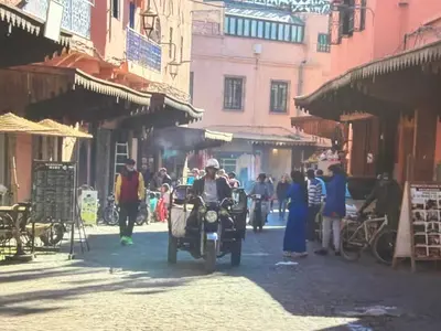 a man riding a motorcycle down a city street at Urban Escape in Marrakesh in Marrakech