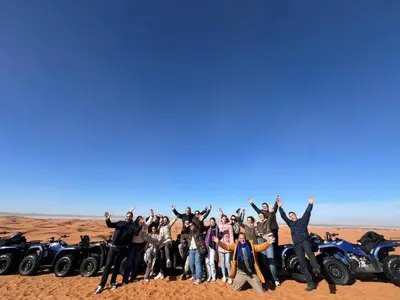 a group of people standing in the desert with their motorcycles at Menara Airport Transfers in Marrakech